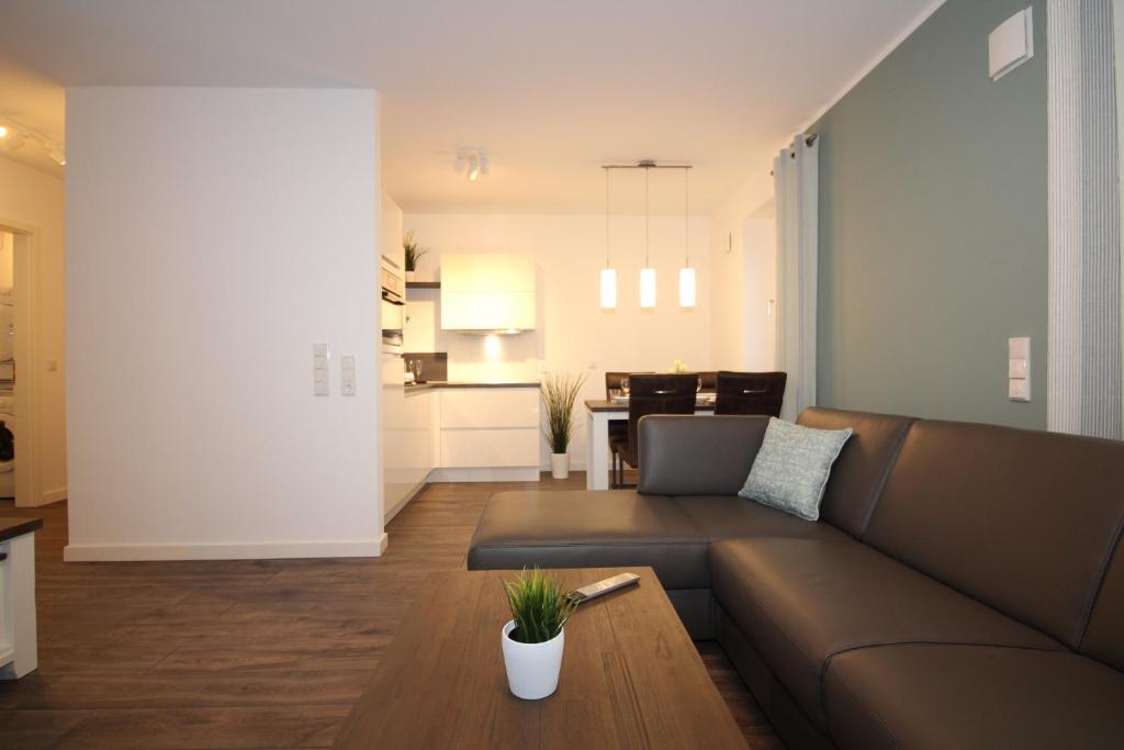 a living room with a couch and a table at Wohnen am Yachthafen W25 in Cuxhaven