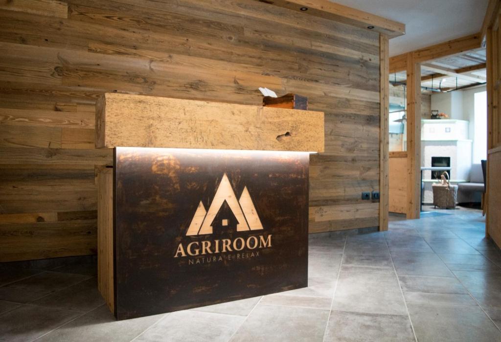 ein Schild für Aathron in einem Zimmer mit Holzwänden in der Unterkunft Agriroom in Rumo