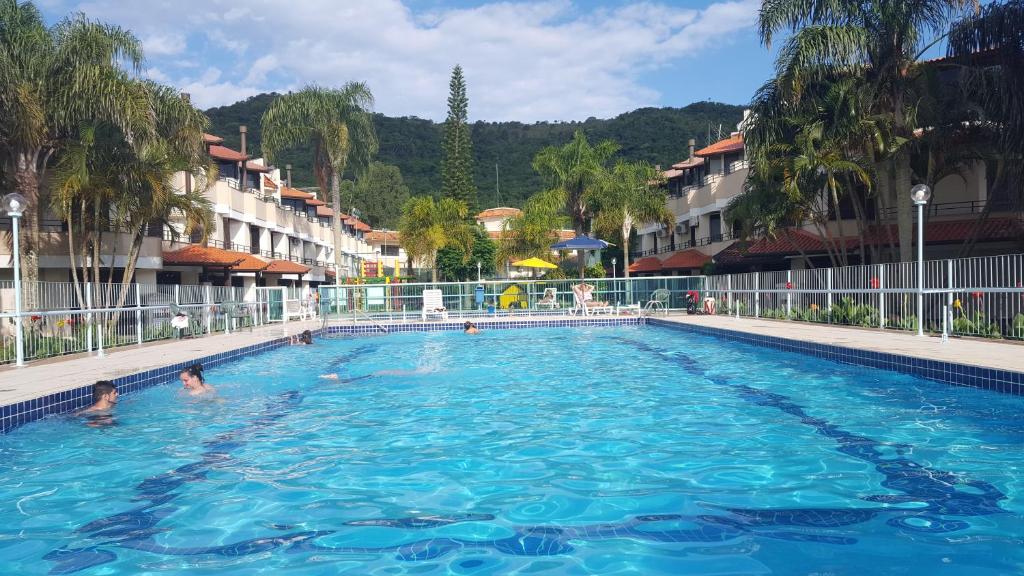 - une grande piscine avec des personnes à l'eau dans l'établissement Vivendas de Maiorca, à Florianópolis