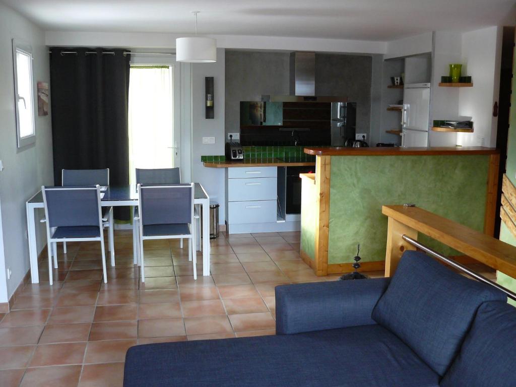 a living room with a table and chairs and a kitchen at Appartement dans maison Entre Savines et Embrun in Crots