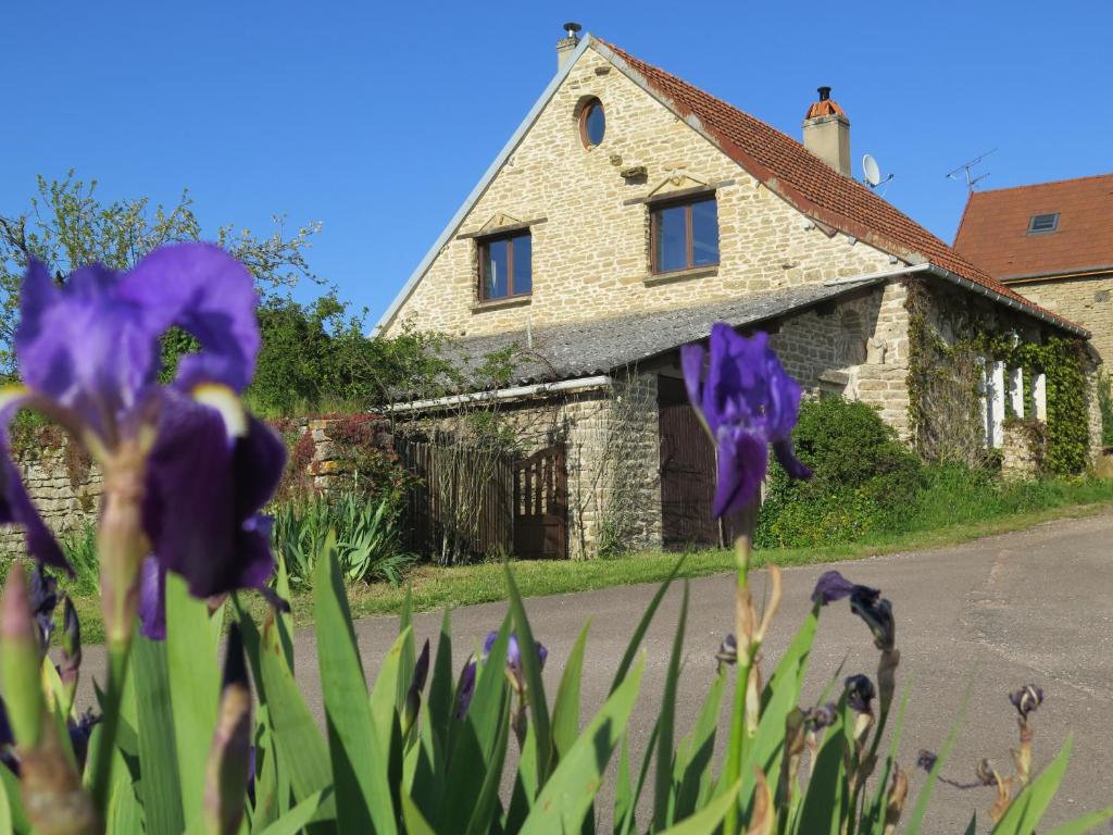 dom z fioletowymi kwiatami przed nim w obiekcie Au verger de Marcilly w mieście Marcilly-Ogny