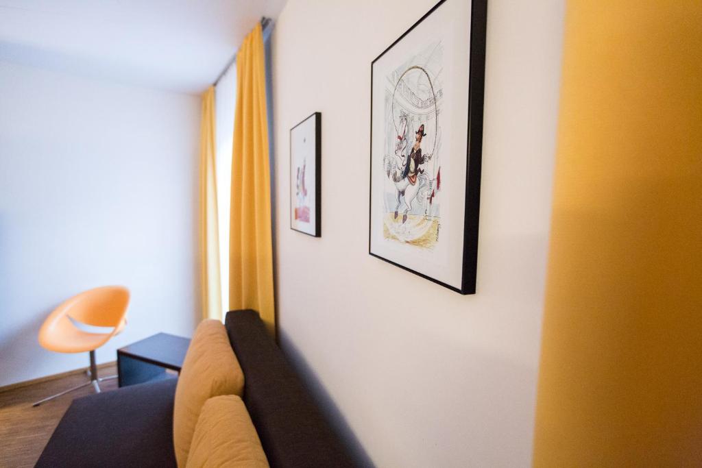 a living room with a couch and pictures on the wall at arte Hotel Krems in Krems an der Donau
