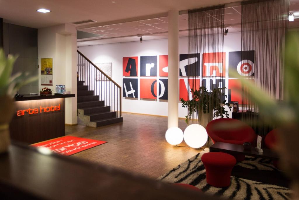 a lobby with a staircase and a red chair at arte Hotel Krems in Krems an der Donau