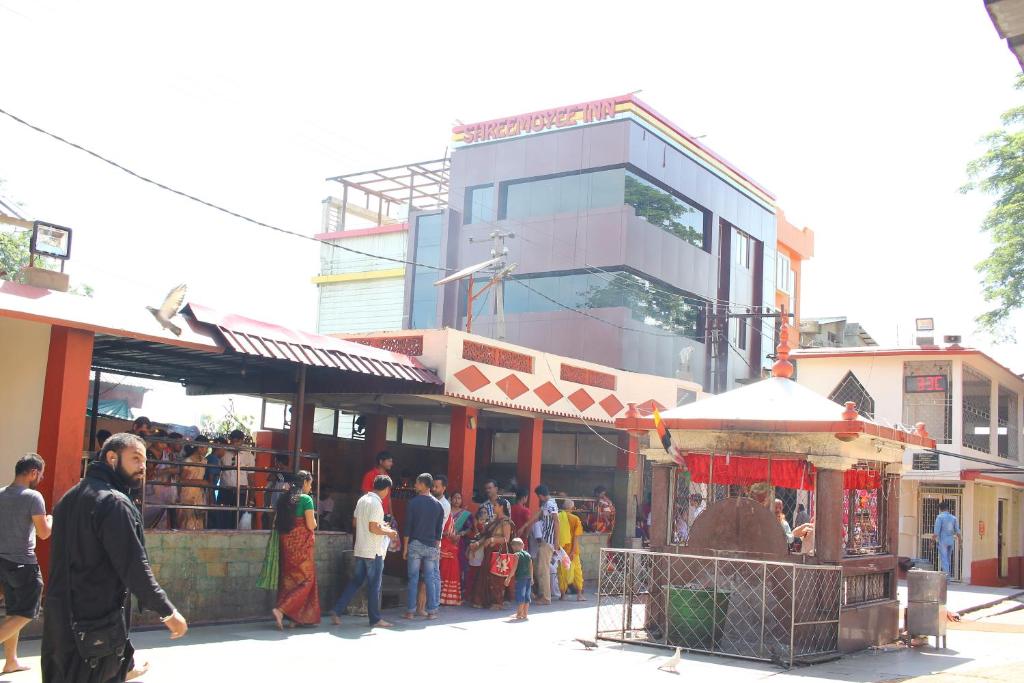 een groep mensen die buiten een gebouw staan bij Hotel Shreemoyee Inn - Kamakhya Temple in Guwahati