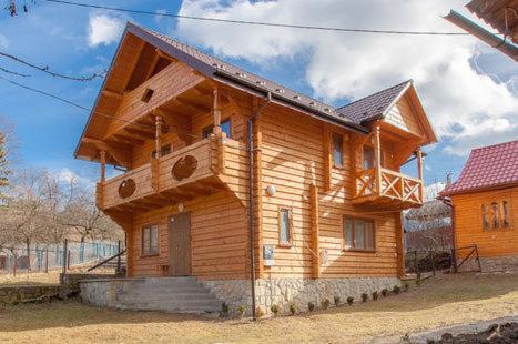 ヤレムチャにあるKarpatskyi Diamantのポーチと階段のある大きな木造家屋