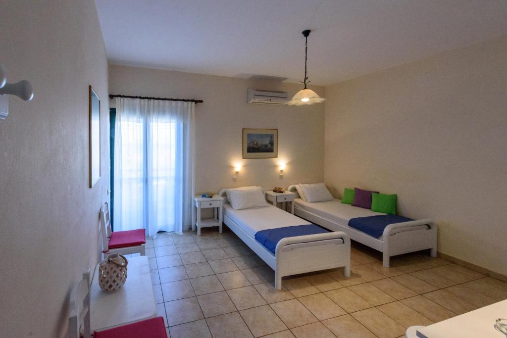 a hotel room with two beds and a table at Angelika in Stoupa