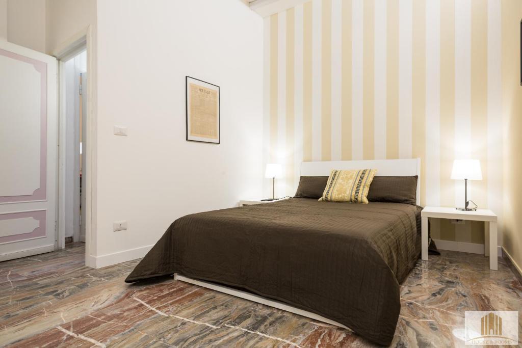 a bedroom with a bed with two lamps on it at Camere Pallotta in Macerata