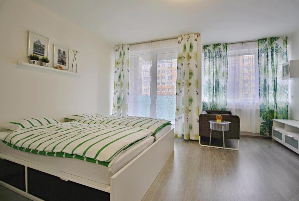 ein Schlafzimmer mit großem Bett und Fenster in der Unterkunft Nice and refreshing flat in Prague in Prag