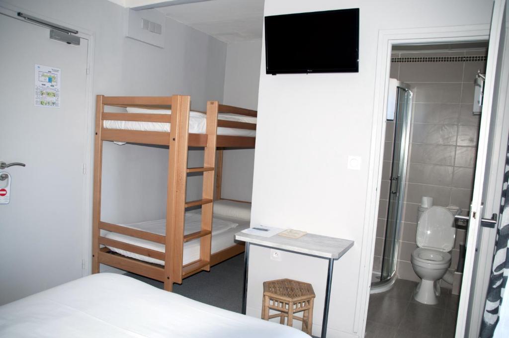a bedroom with a bunk bed and a bathroom with a toilet at Hotel Bleu Azur in Argelès-sur-Mer