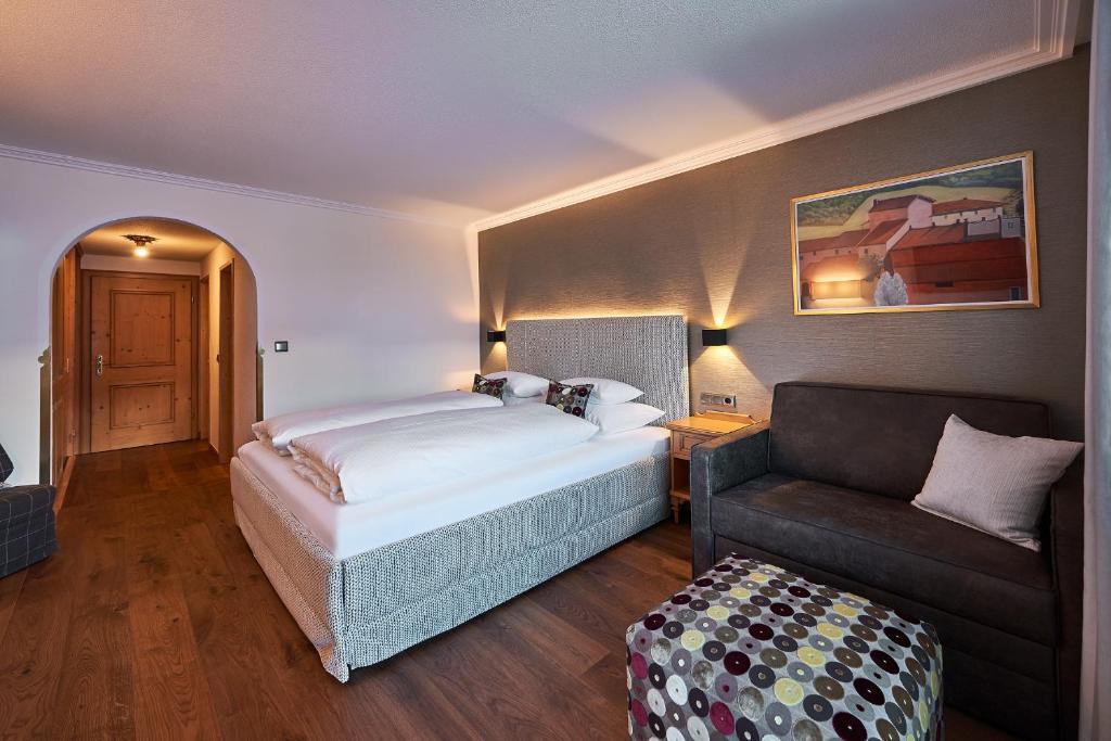 1 dormitorio con 1 cama y 1 sofá en Hotel Garni Edelweiss, en Lech am Arlberg