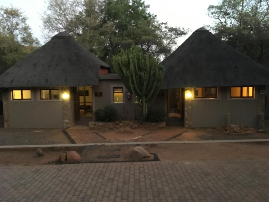 uma casa com dois telhados de palha e uma entrada em Mabalingwe Elephant Lodge em Bela-Bela