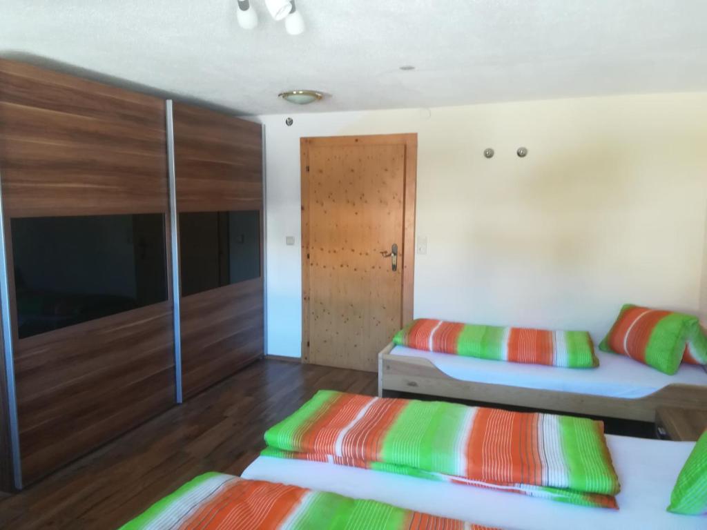 two beds in a room with wooden floors at Bauernhaus Fankhauser in Hippach