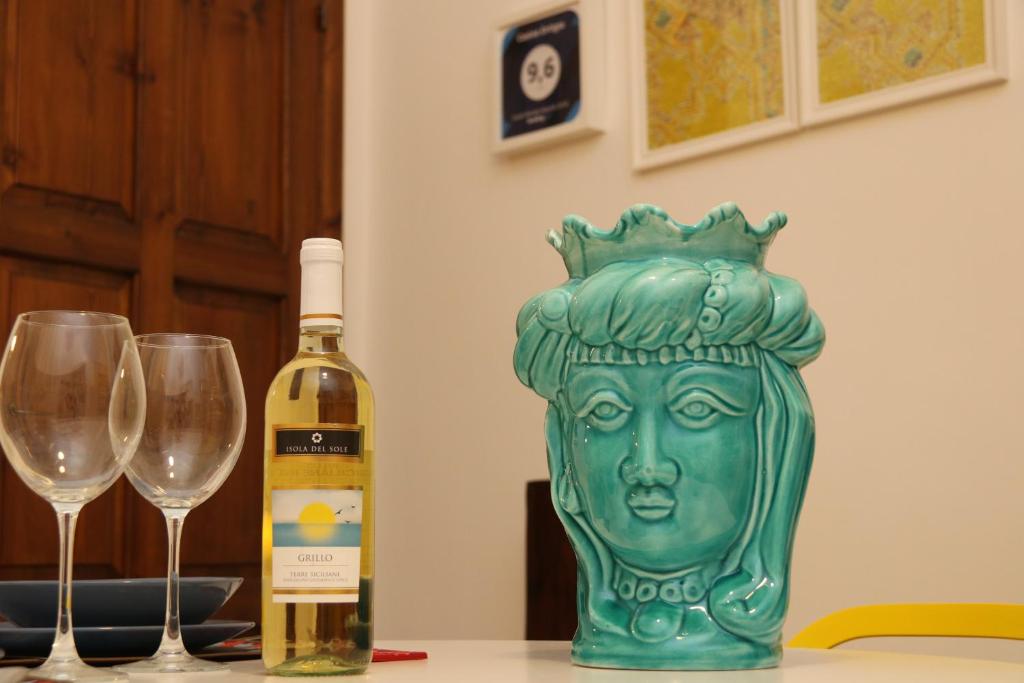 Una botella de vino y dos copas en una mesa. en Casina Ortigia, en Siracusa