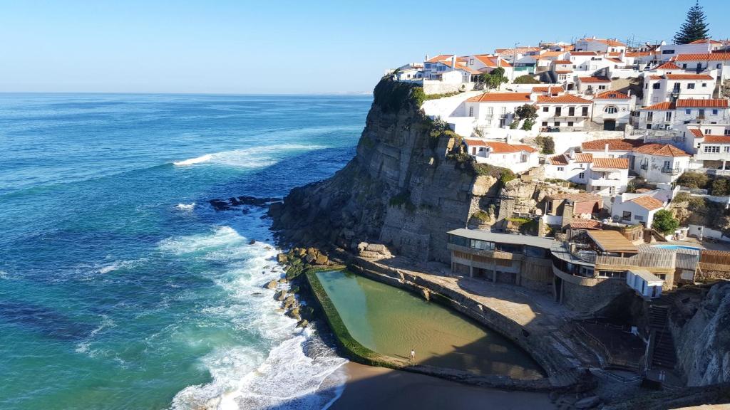 een luchtzicht op een dorp op een klif naast de oceaan bij Magoito Beach Apartment in Sintra