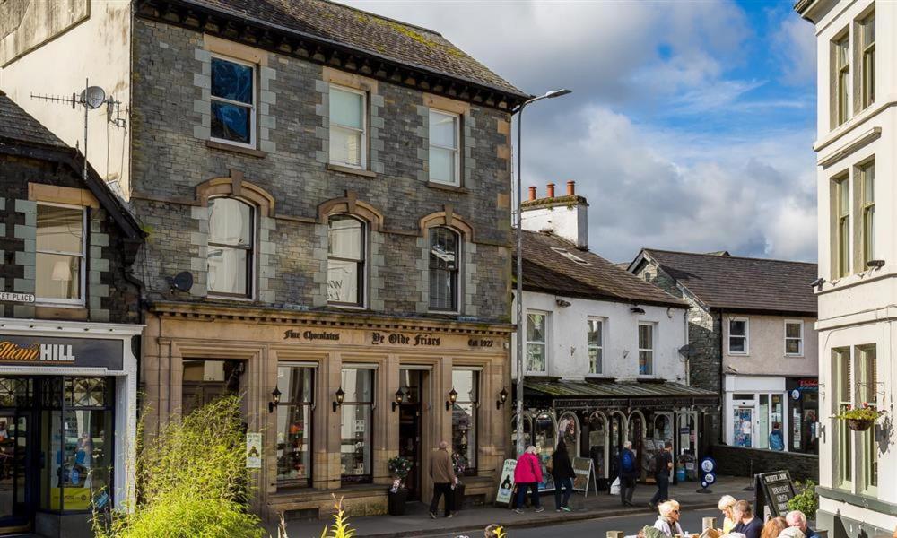 un grupo de personas caminando por una calle de la ciudad en No 1, Midland Bank Chambers, en Ambleside