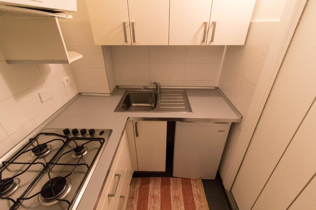 uma pequena cozinha com um lavatório e um fogão em Azzurro em Turim