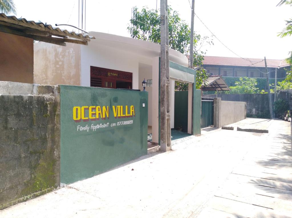a building with a green sign on the side of it at Ocean Villa in Beruwala