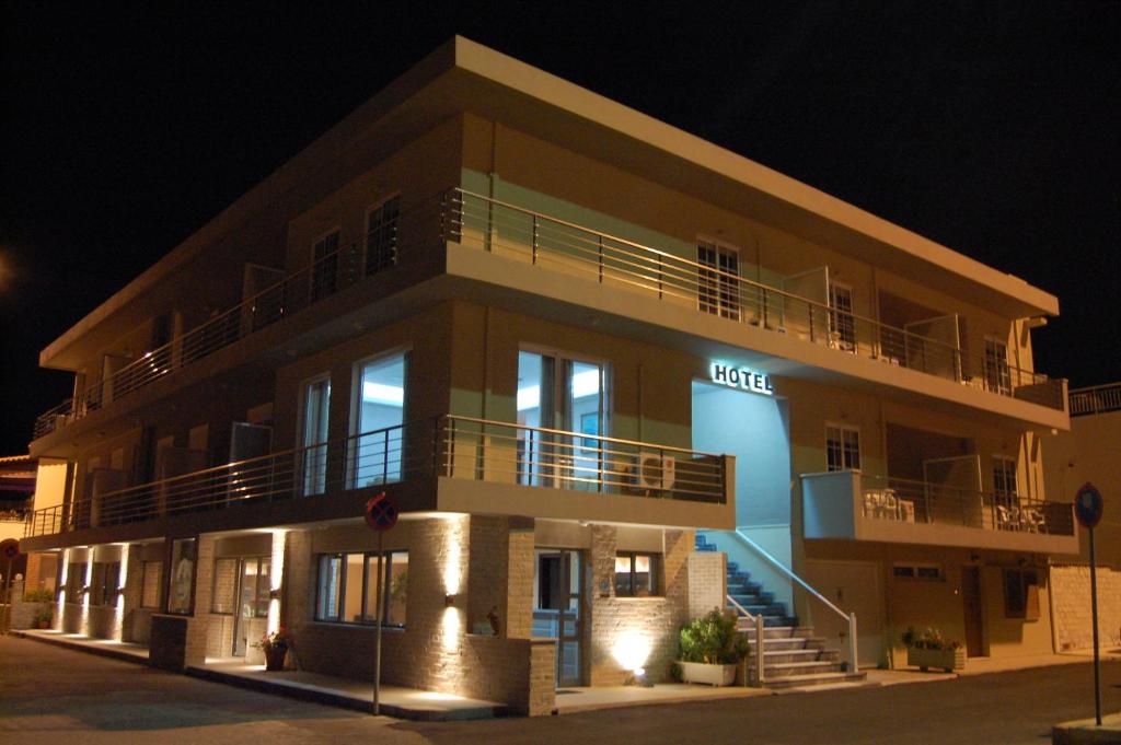 a building with a lit up sign in front of it at Hotel Antirrio in Antirrio