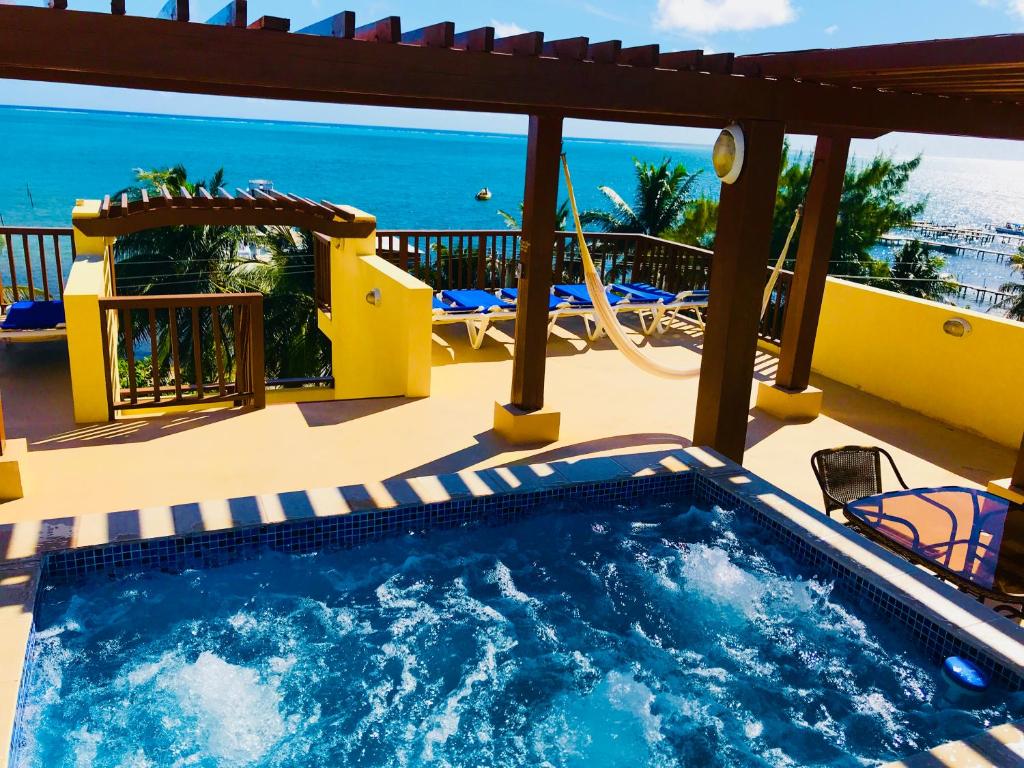 a swimming pool on a patio with a view of the ocean at Caye Reef Condos in Caye Caulker