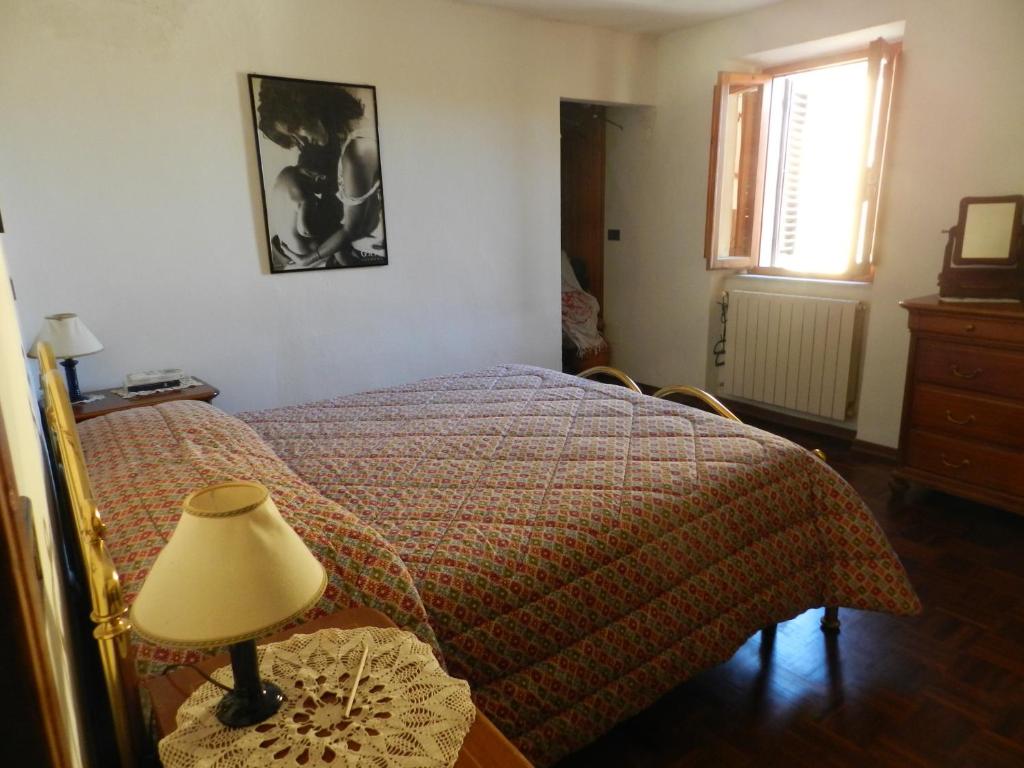 ピストイアにあるLa Casinaのベッドルーム1室(ベッド1台、テーブルの上にランプ付)