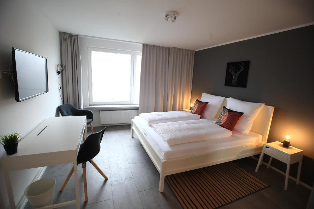 Schlafzimmer mit einem Bett, einem Schreibtisch und einem Fenster in der Unterkunft 1Step2AllCities House&Garden in Wuppertal