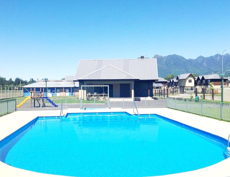 una gran piscina azul frente a una casa en Casa en Pucón, en Pucón