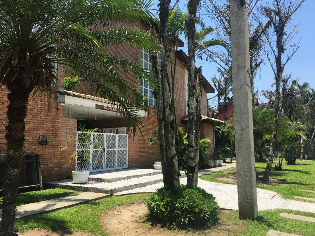 a brick house with palm trees in front of it at Casa Riviera de São Lourenço in Riviera de São Lourenço