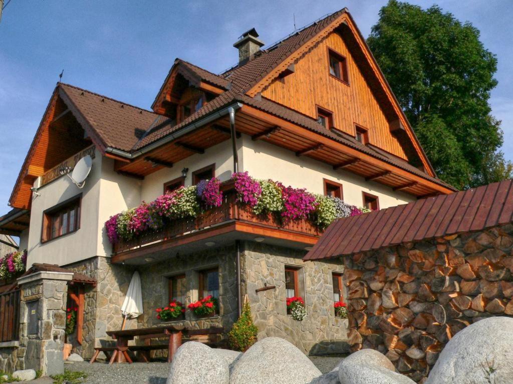 una casa con flores a un lado. en VILA Tatry Ždiar, en Ždiar