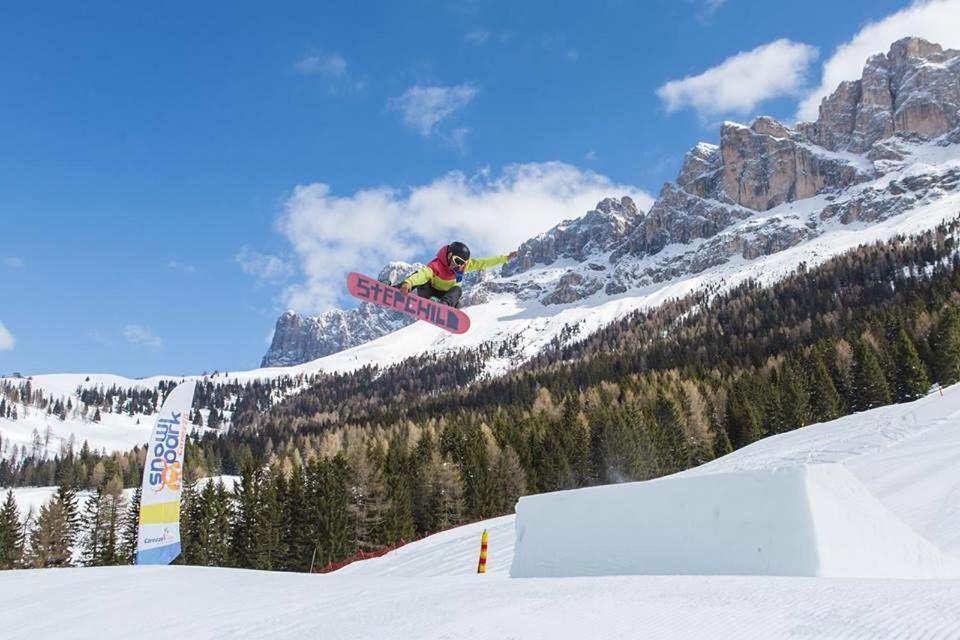 snowboarder robi sztuczkę w powietrzu w obiekcie Majon de la nona w mieście Pozza di Fassa