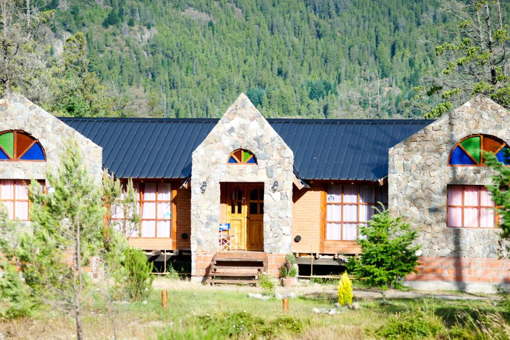 Casa de madera con techo azul y ventanas en El hostel secreto en Lago Puelo