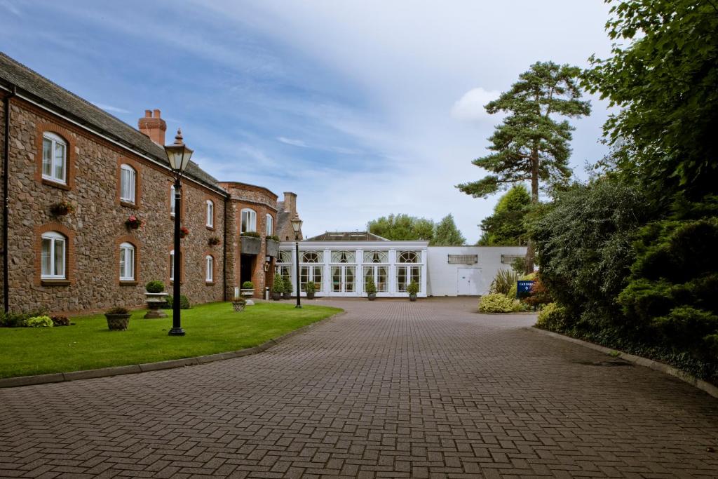 uma entrada em frente a um grande edifício de tijolos em Quorn Country Hotel em Loughborough