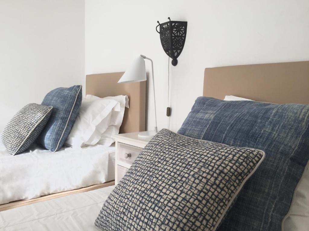 1 dormitorio con 2 camas con almohadas y lámpara en Quarteira Paul Harris Apartment, en Quarteira