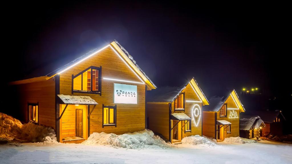 シェレゲシュにあるPanda houseの夜雪の木造建築