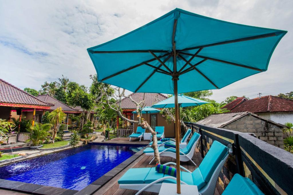 une villa avec une piscine et un parasol bleu dans l'établissement Blue Lagoon Secret Villas, à Nusa Lembongan