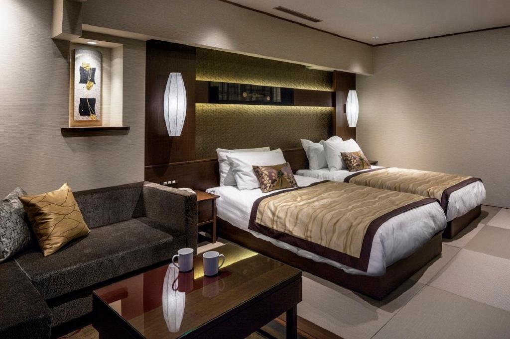 a hotel room with a bed, chair, table and lamp at ANA Holiday Inn Kanazawa Sky, an IHG Hotel in Kanazawa