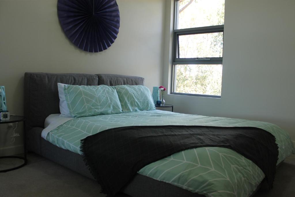a bedroom with a bed with green sheets and a window at Exquisite Family Home +Parking, Close to CBD in Sydney