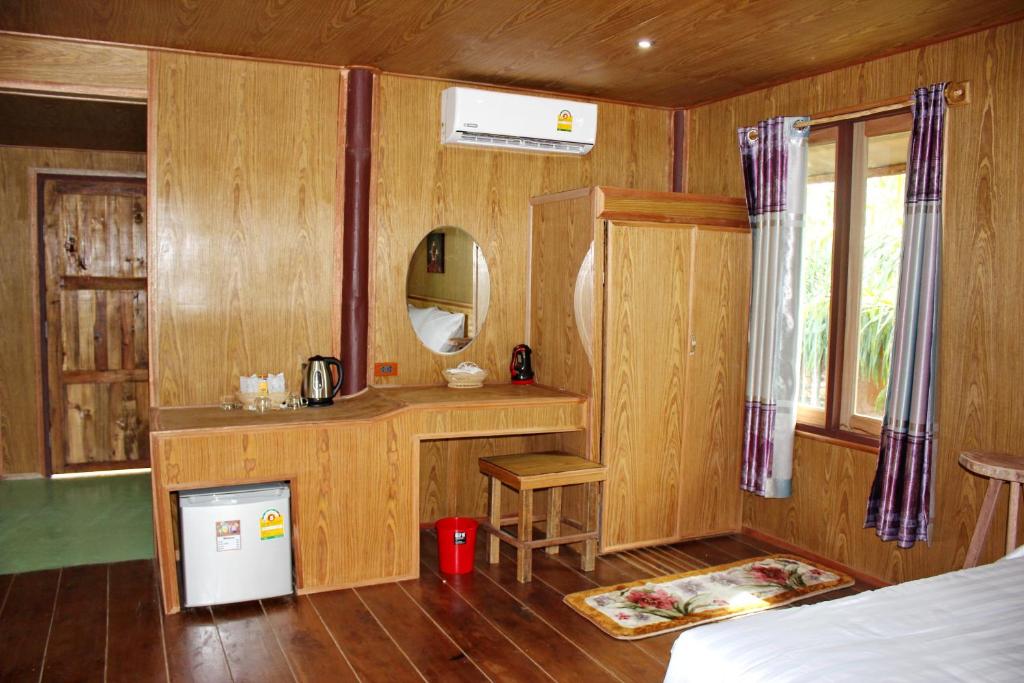 a bedroom with a bed and a table and a mirror at YaoIsland Resort and Farm in Ko Yao Yai