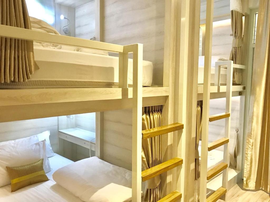 two bunk beds in a small room with a bed at Mariya Lady Hostel At Suvarnabhumi Airport in Lat Krabang