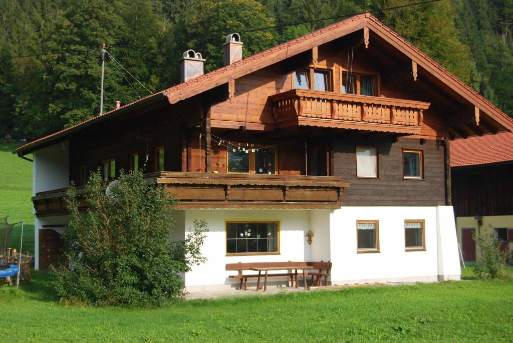 une grande maison en bois avec une table de pique-nique devant elle dans l'établissement Ferienwohnung Familie Schweiger, à Ramsau bei Berchtesgaden