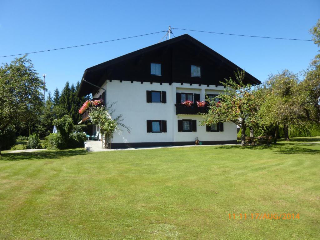 una gran casa blanca con techo negro en Gästehaus Resei en Schiefling am See