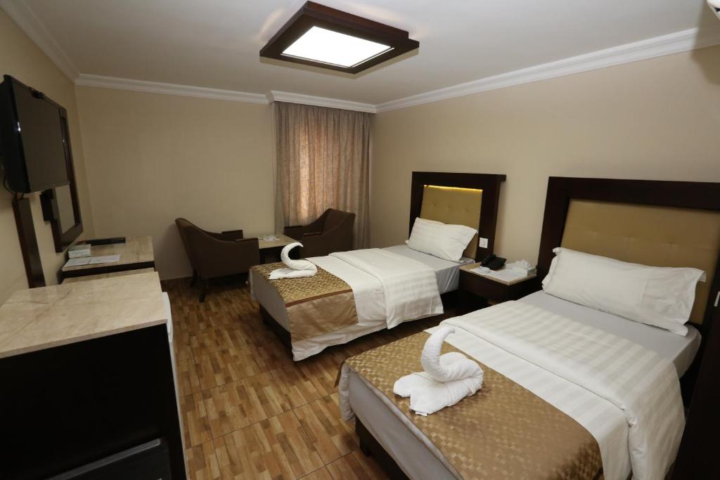 A bed or beds in a room at Al Zaitouna Hotel