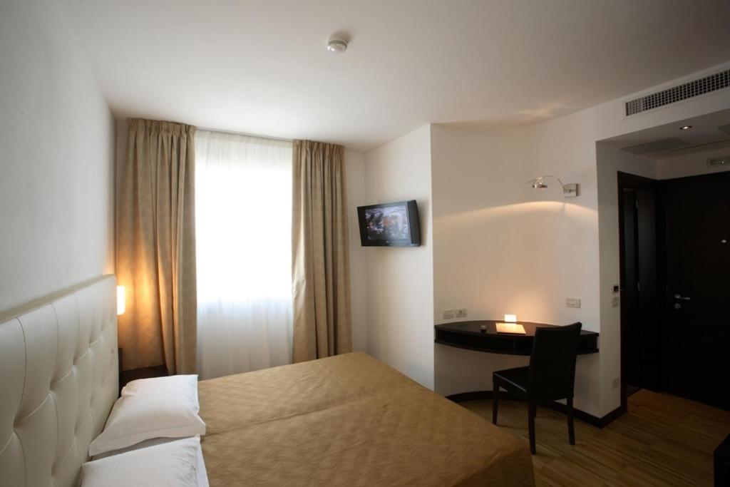 a hotel room with a bed and a desk at San Marco in Montecchio Maggiore