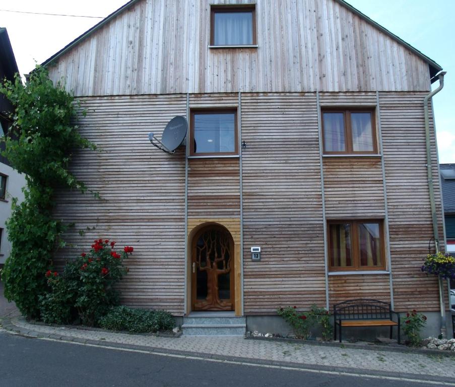 a large wooden building with a wooden door at Ferienapartments am Dorfplatz in Langscheid