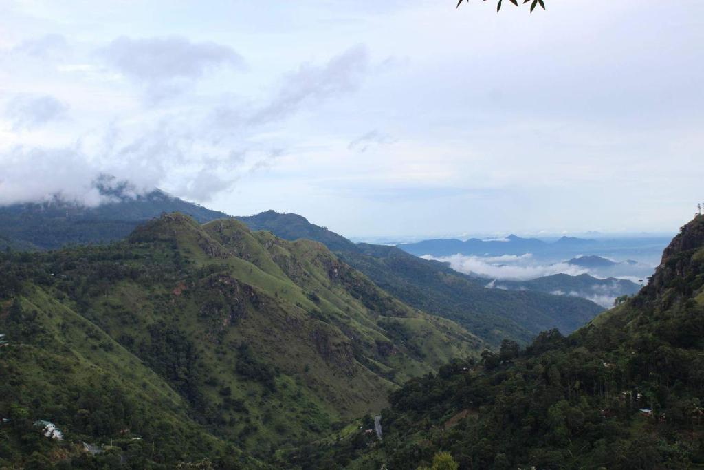a view of a mountain range with clouds in the distance at Amado Homestay Ella in Ella