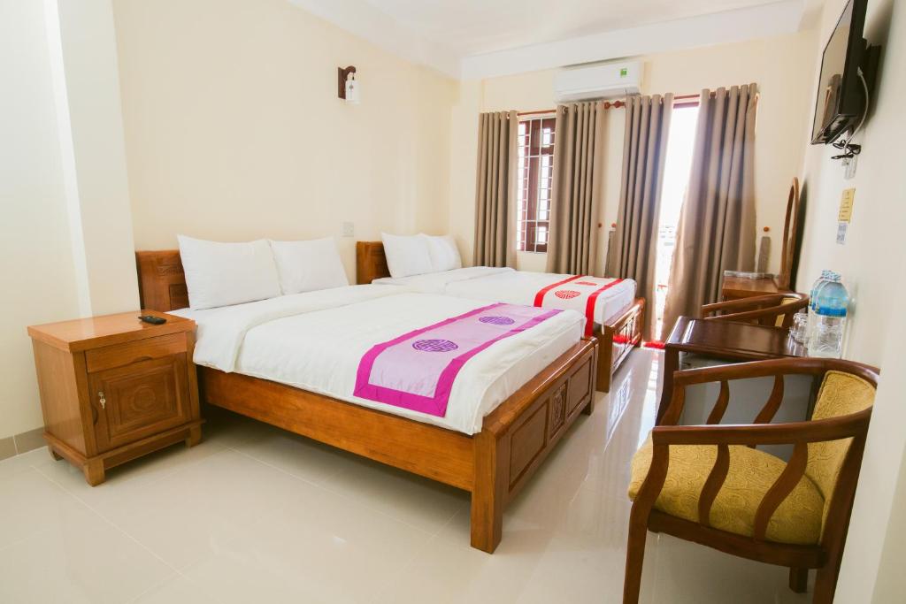 a bedroom with a bed and two chairs in it at Binh An hotel in Nha Trang