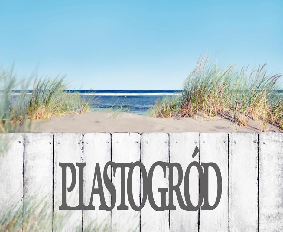 una cerca con la palabra Pasadena escrita en ella junto a una playa en Piastogród en Jarosławiec