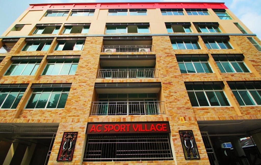 a tall brick building with a sign on it at AC Sport Village in Bangkok