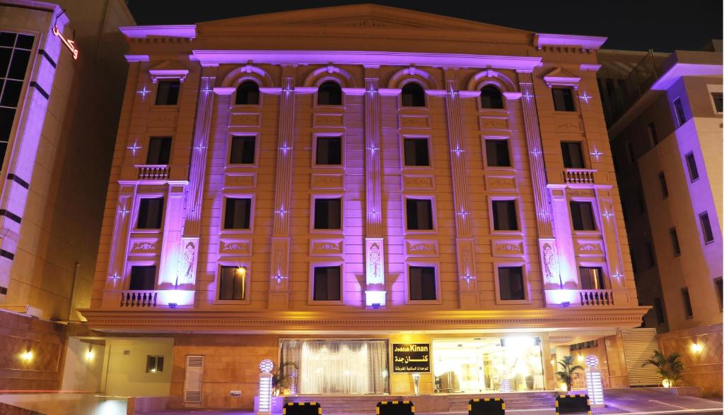 un edificio iluminado por la noche con luces púrpuras en Sakan com Jeddah en Yeda