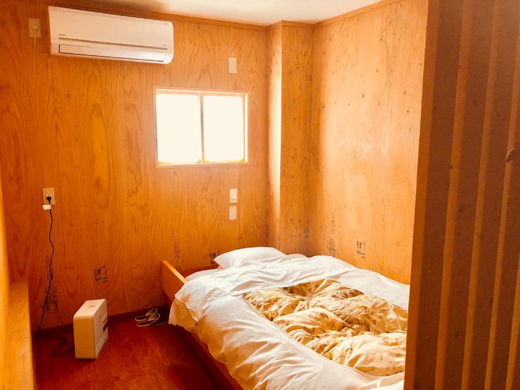 小樽的住宿－小樽和之風旅館，一间带床的卧室,位于带窗户的房间内
