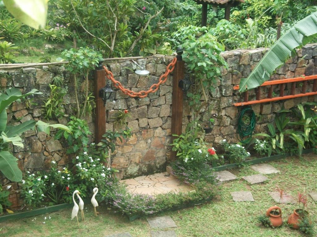 a garden with a gate and a stone wall at Portal dos Borbas in Abraão